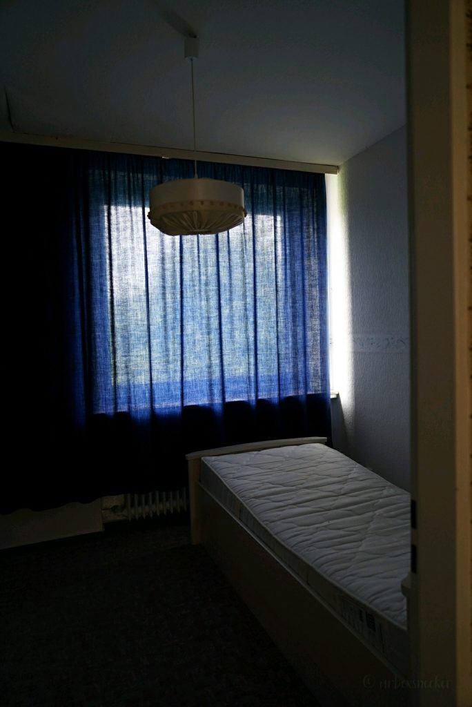 verlassenes waldhotel im harz mit blauen vorhängen