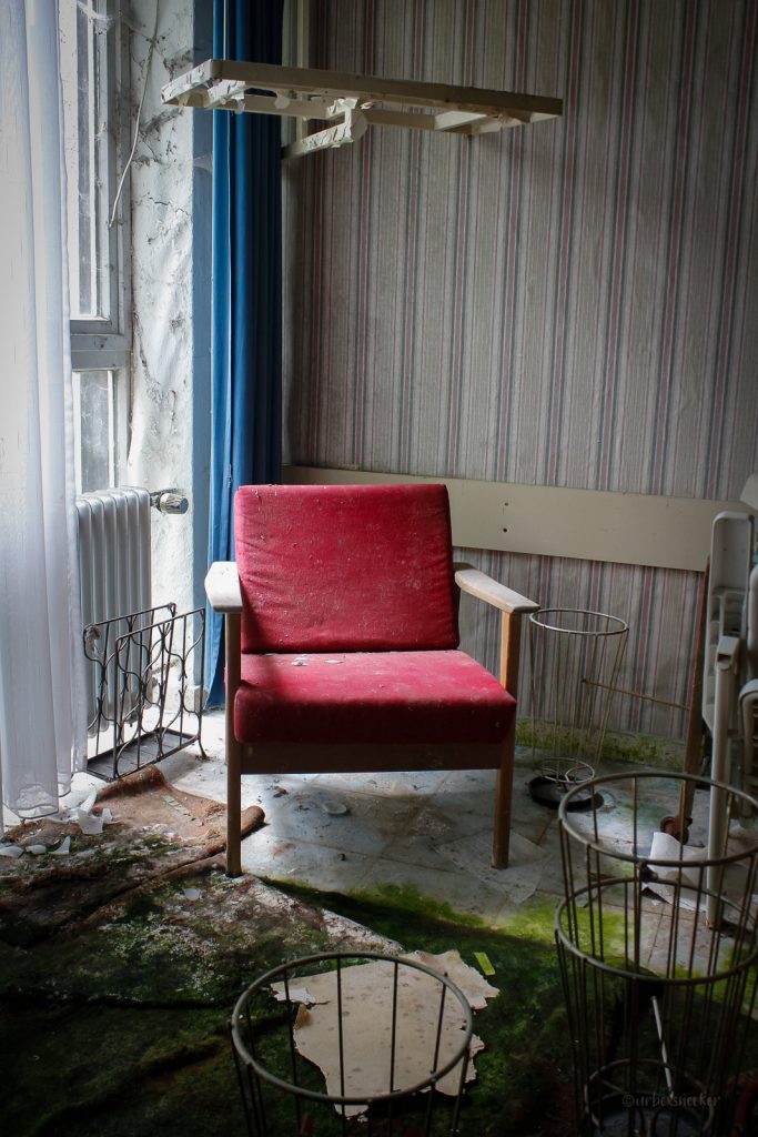 roter stuhl im verlassenen lampen-hotel
