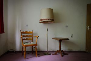 szene von stuhl mit tisch und lamep im lost place hotel